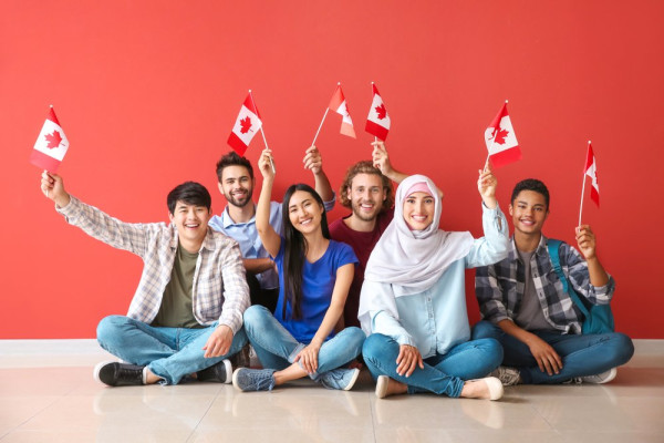 A group of people sitting on the floor holding flagsDescription automatically generated