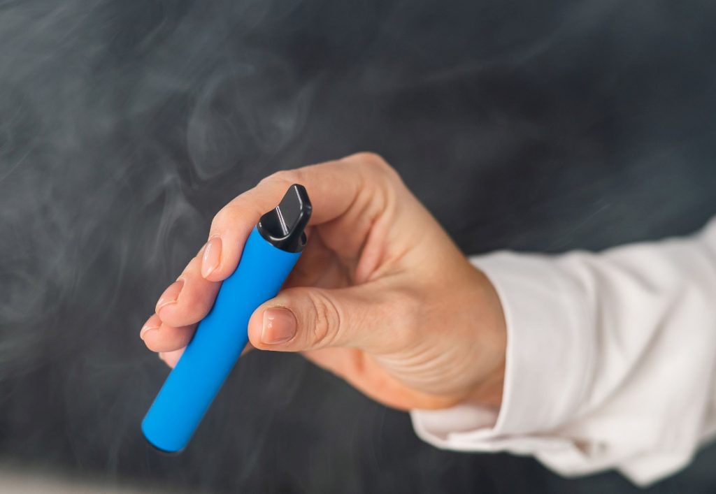 A hand holding a blue disposable-pod