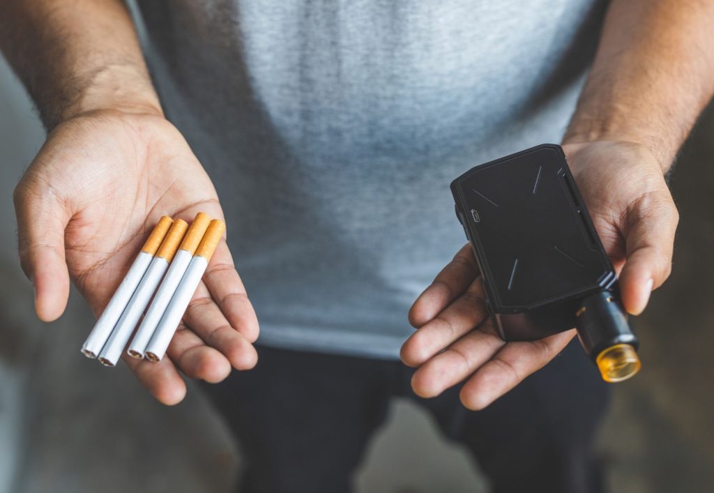 A person holding cigarettes and a wallet